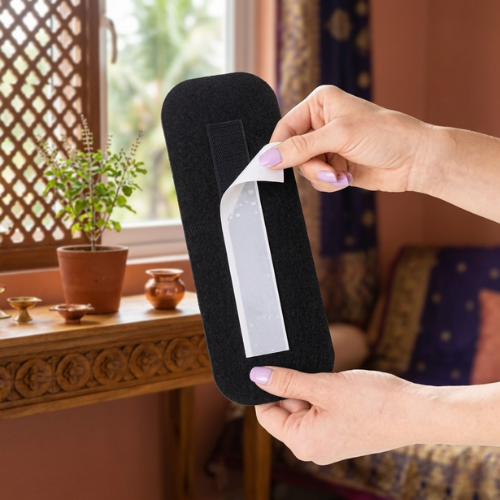 Black ceiling fan filter pad held in hands, rectangular felt with label